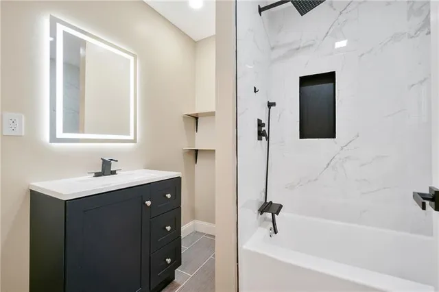 a bathroom with a tub sink and mirror