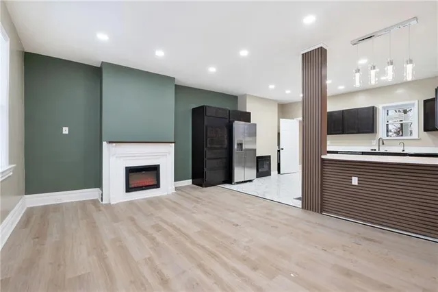 a large kitchen with a sink and a fireplace