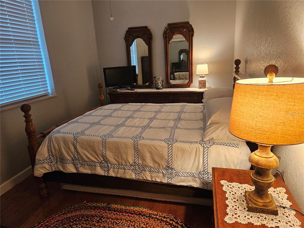 668 American Legion Drive Madeira Beach, FL 33708 - Photo 26 of 49 a bedroom with a bed and dresser with mirror