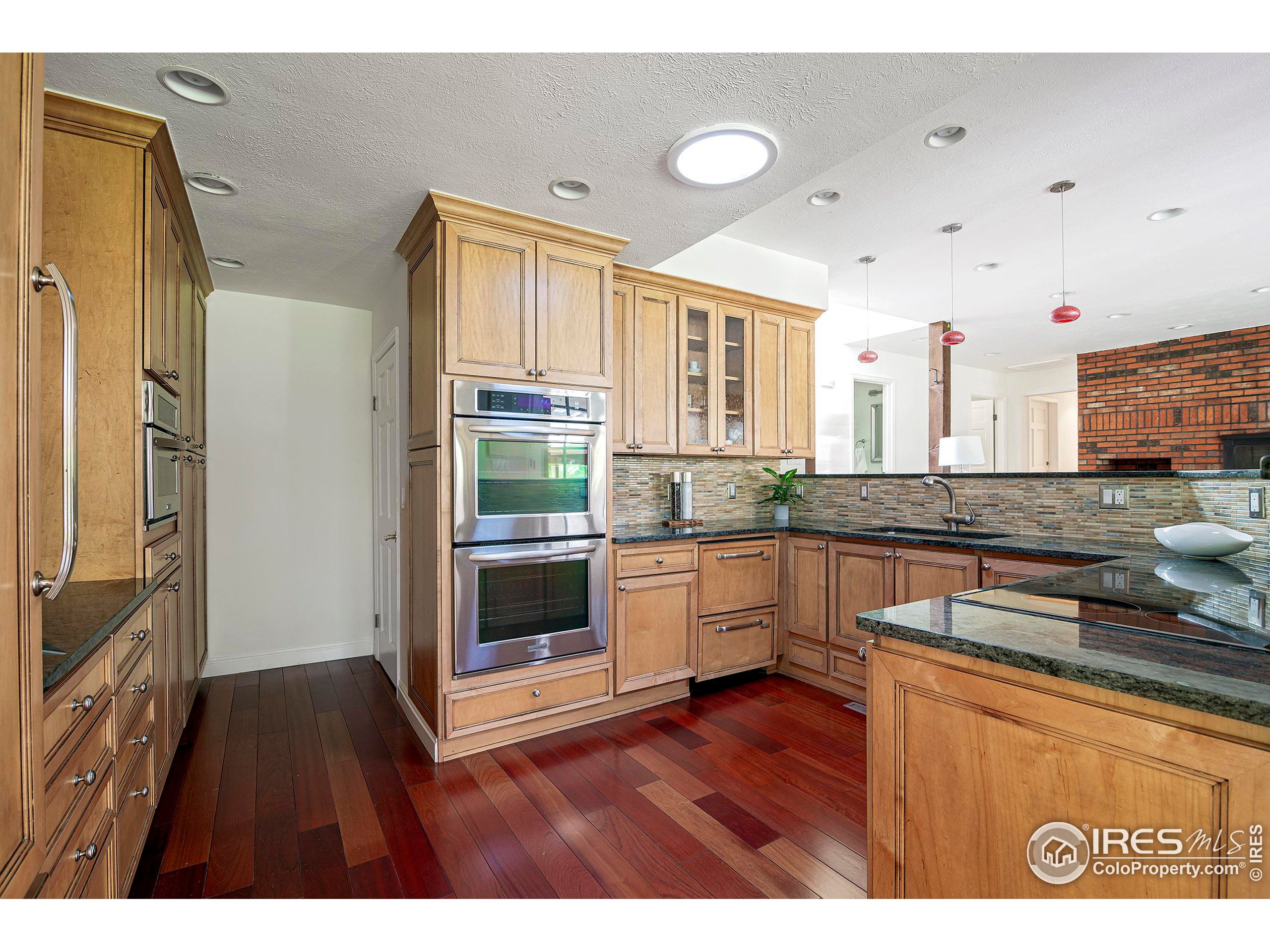 7700 O Connor Road Boulder, CO 80303 - Photo 17 of 40 a kitchen with stainless steel appliances granite countertop a stove a sink and a refrigerator with wooden floors