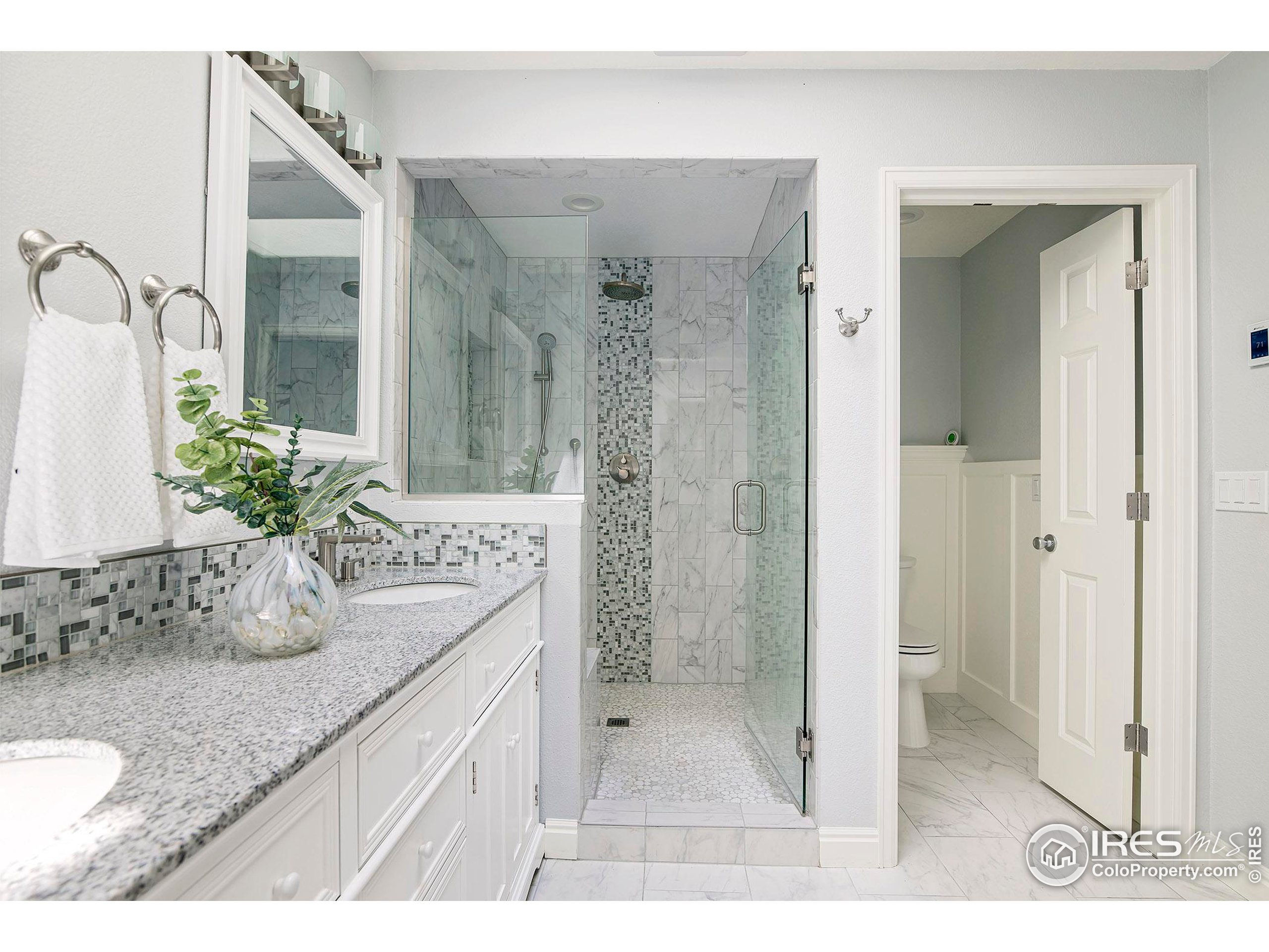 7700 O Connor Road Boulder, CO 80303 - Photo 27 of 40 a bathroom with a granite countertop sink a mirror and a shower