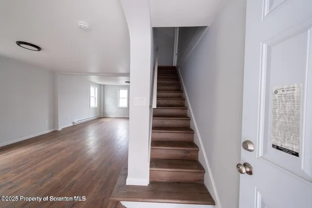 a view of entryway and hall with wooden floor
