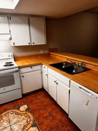 a kitchen with white cabinets and white appliances