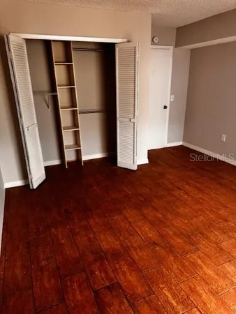 a view of empty room with wooden floor and window