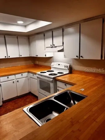 a kitchen with stainless steel appliances a stove a sink and a microwave