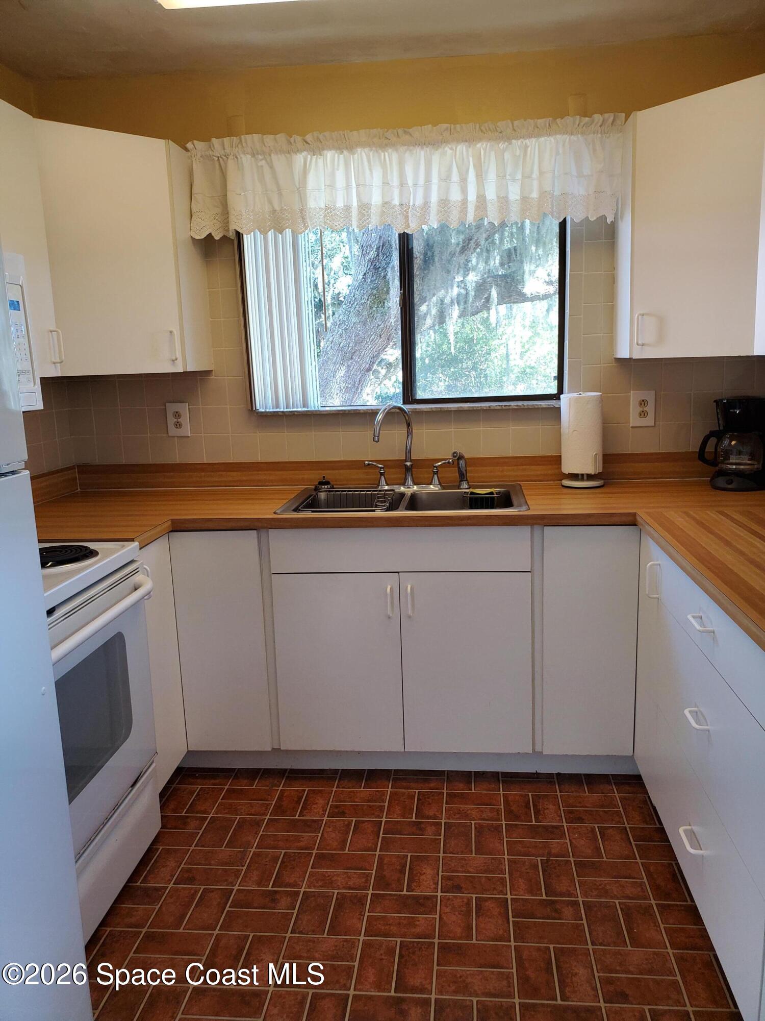 2324 Bignonia Street, Unit 2 Melbourne, FL 32901 - Photo 5 of 19 a kitchen with a sink a stove and cabinets