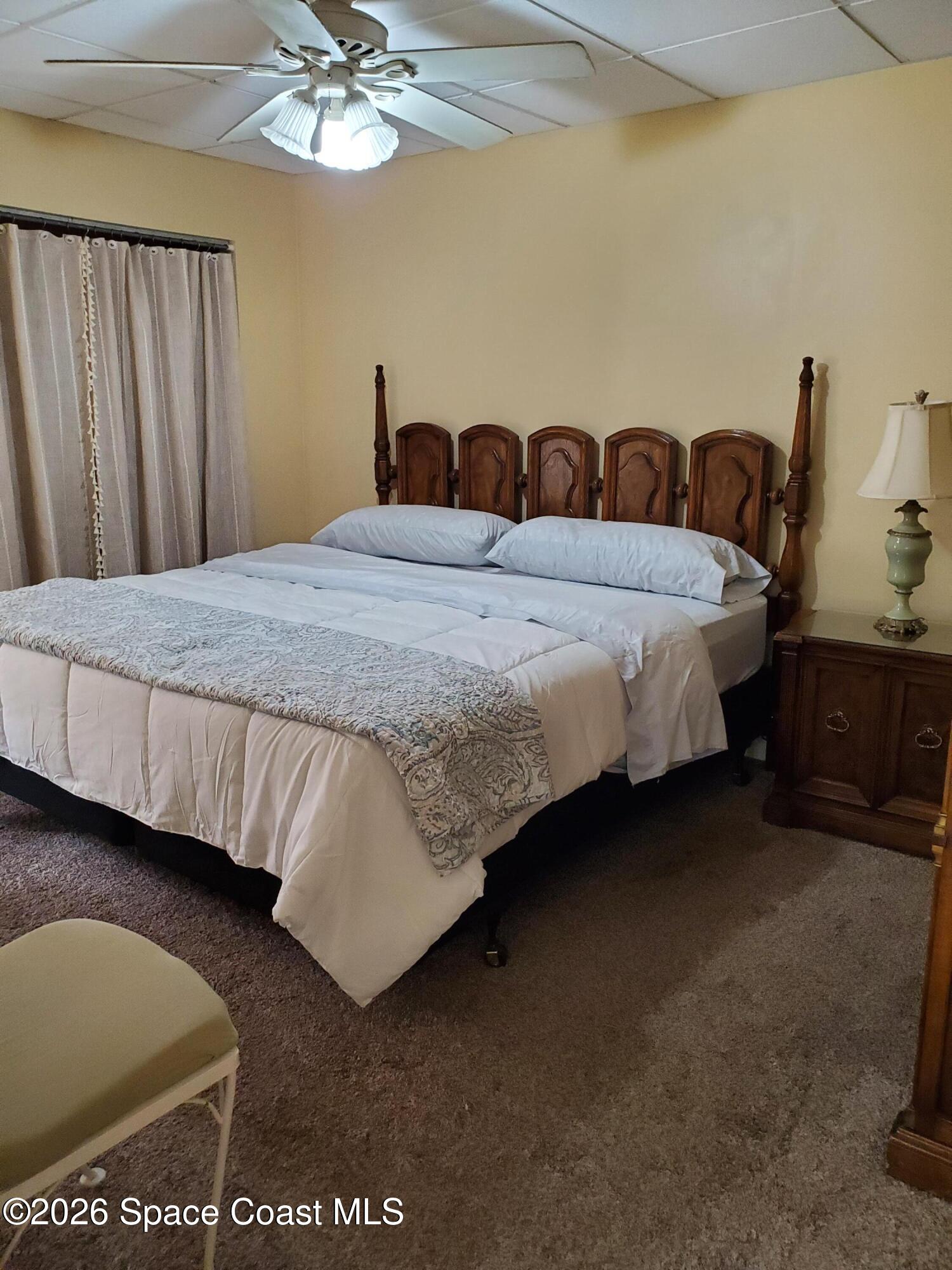 2324 Bignonia Street, Unit 2 Melbourne, FL 32901 - Photo 8 of 19 a bedroom with a bed and a chandelier