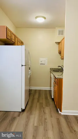 a kitchen with granite countertop a sink and dishwasher cabinets with wooden floor