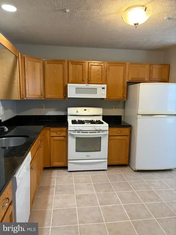 a kitchen with a stove a refrigerator and a sink