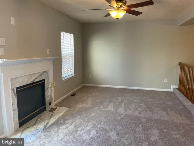 a view of an empty room with window and a fireplace