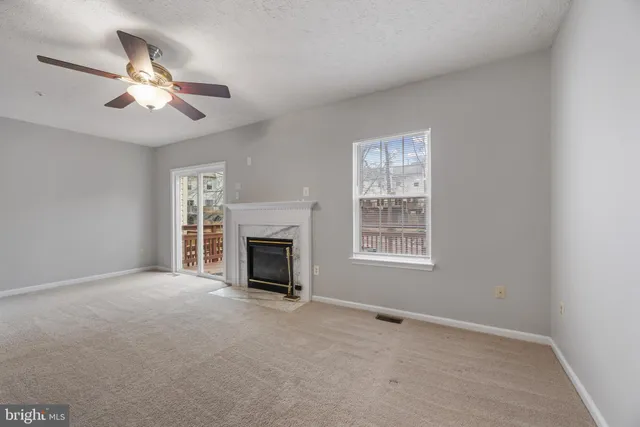 a view of livingroom with window fireplace and ceiling fan