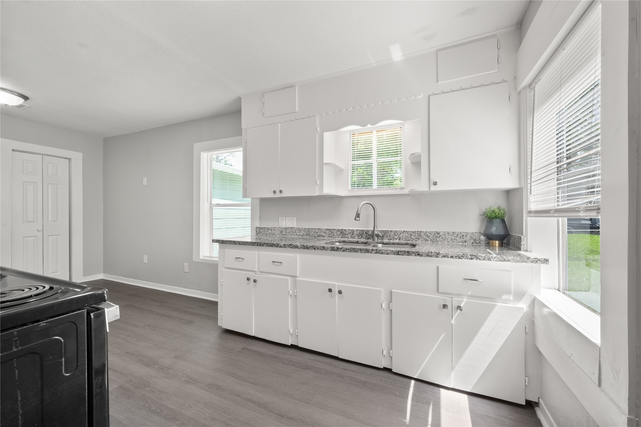 9210 Compton Street Houston, TX 77016 - Photo 18 of 50 Bright kitchen with modern granite countertops, abundant natural light, and sleek white cabinetry.