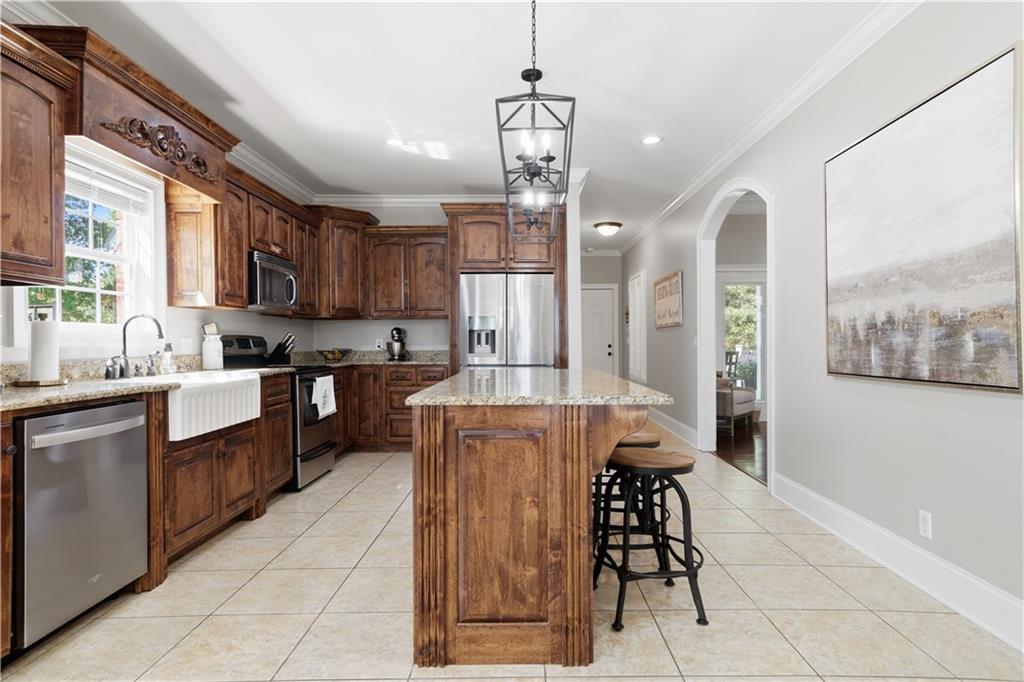 310 Gaines Road Southeast Dalton, GA 30721 - Photo 12 of 53 a kitchen with stainless steel appliances granite countertop a refrigerator a sink dishwasher a stove and a dining table with wooden floor