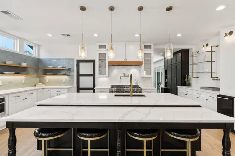 a large kitchen with kitchen island a sink table and chairs