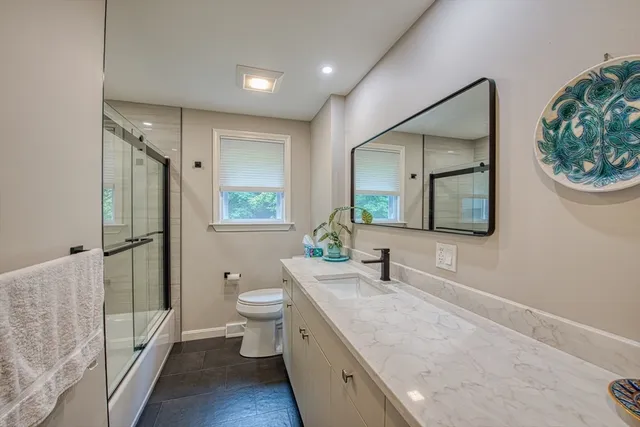 a spacious bathroom with a toilet a sink and a large mirror