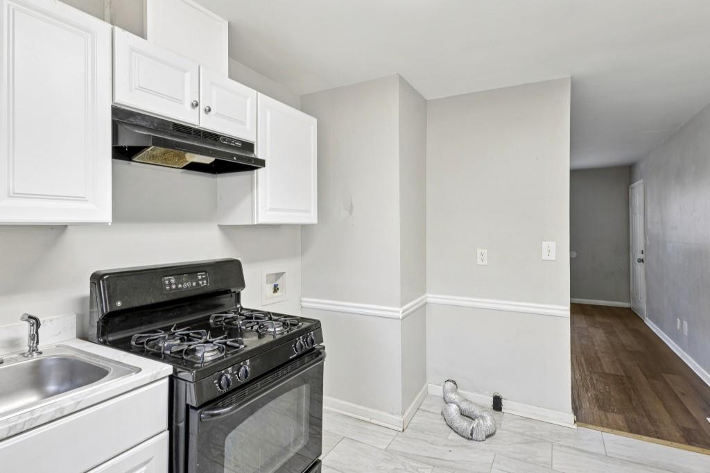 61 Pine Street Northeast Fairburn, GA 30213 - Photo 11 of 22 a kitchen with granite countertop a sink stove and cabinets