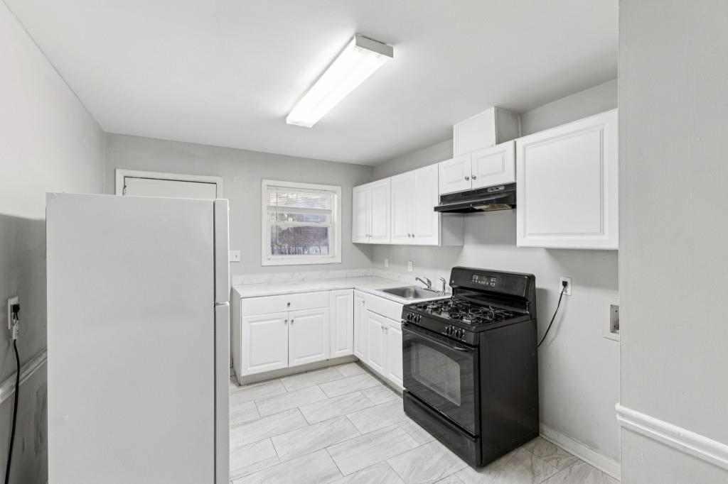 61 Pine Street Northeast Fairburn, GA 30213 - Photo 7 of 22 a kitchen with cabinets appliances a sink and a window