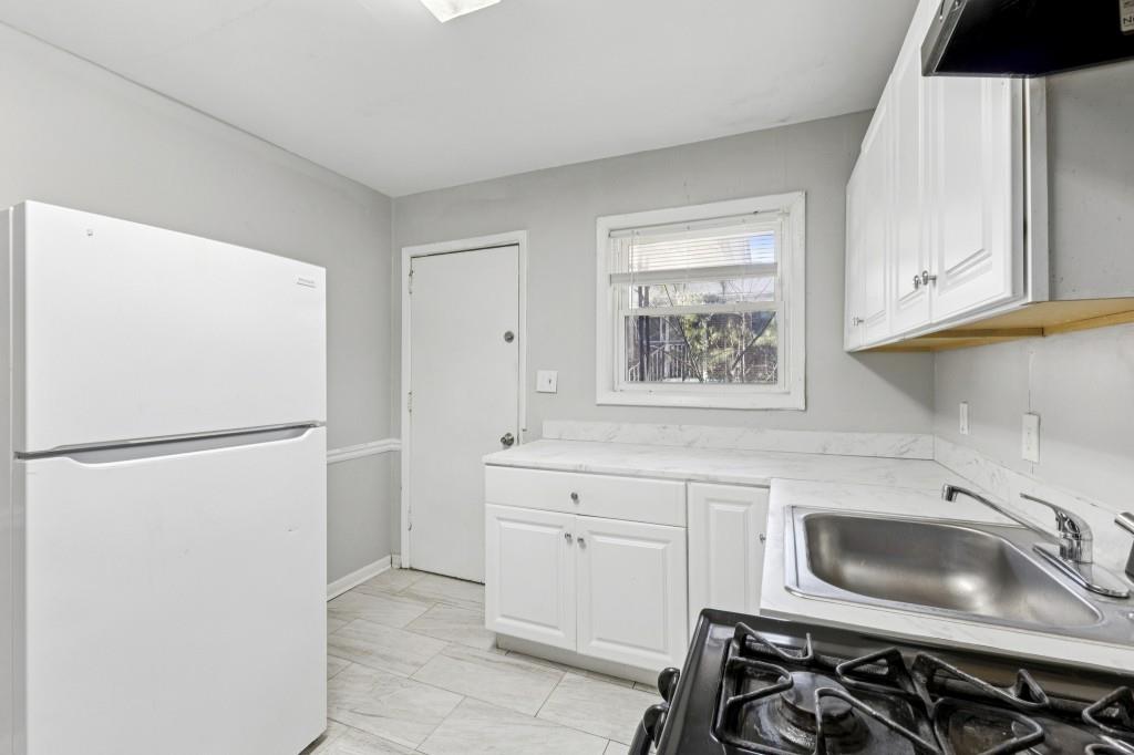 61 Pine Street Northeast Fairburn, GA 30213 - Photo 9 of 22 a kitchen with white cabinets and white appliances