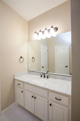 a bathroom with a sink vanity and a mirror