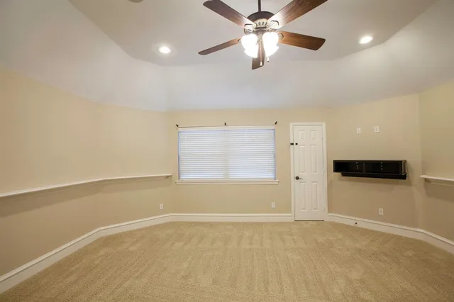 en empty room with windows and ceiling fan