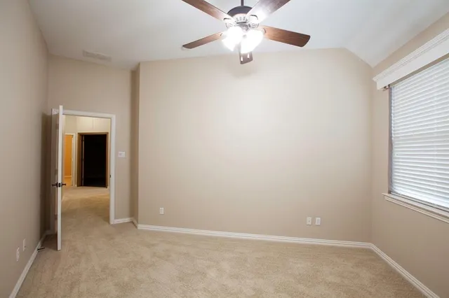 an empty room with a chandelier fan