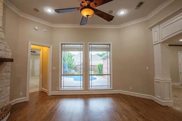 a view of a livingroom with wooden floor and a ceiling fan