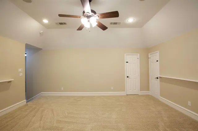 an empty room with ceiling fan and window