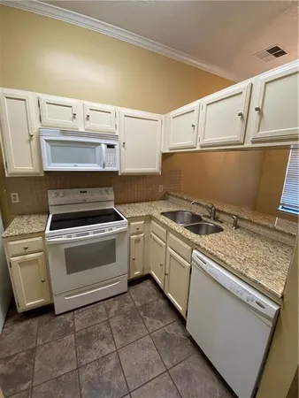 a kitchen with a stove and white cabinets