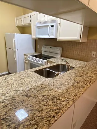 a kitchen with kitchen island a sink a stove and refrigerator