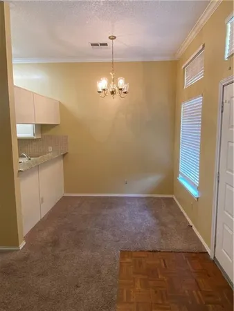 a view of a kitchen with a sink dishwasher a kitchen island a stove with wooden cabinets