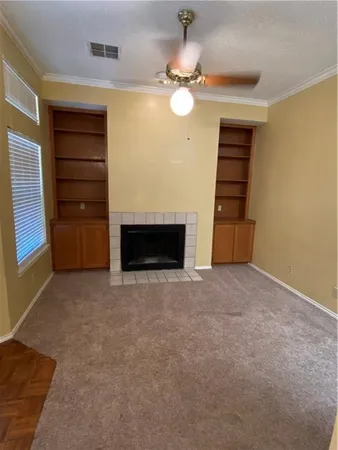 a view of an empty room with a fireplace and a window