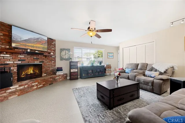 a living room with furniture a fireplace and a flat screen tv