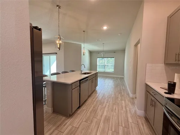 a kitchen with a sink and wooden floor