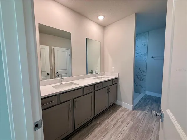 a bathroom with a double vanity sink and mirror
