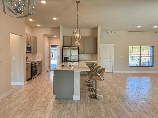 a kitchen with kitchen island a counter top space a sink stainless steel appliances and cabinets