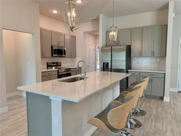 a kitchen with granite countertop a sink a counter space stainless steel appliances and cabinets