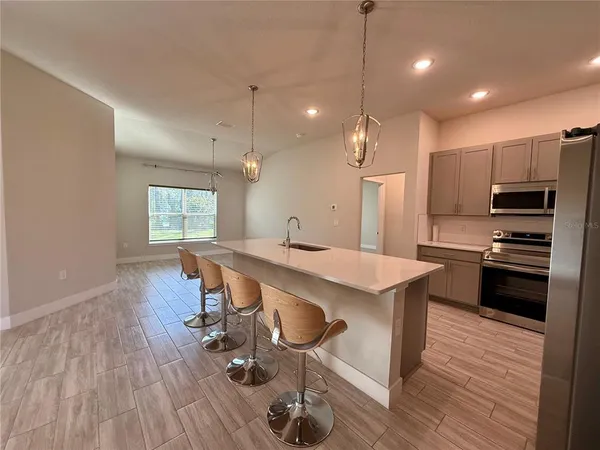 a kitchen with kitchen island a wooden floor and white appliances