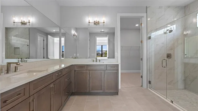 a bathroom with a sink vanity and shower