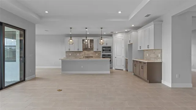 a large white kitchen with a stove a sink dishwasher and a refrigerator