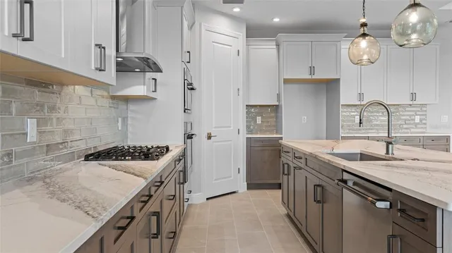 a kitchen with stainless steel appliances granite countertop a sink stove and refrigerator