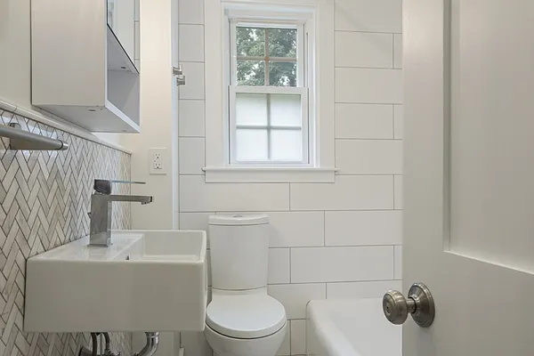 a bathroom with a toilet a sink and mirror