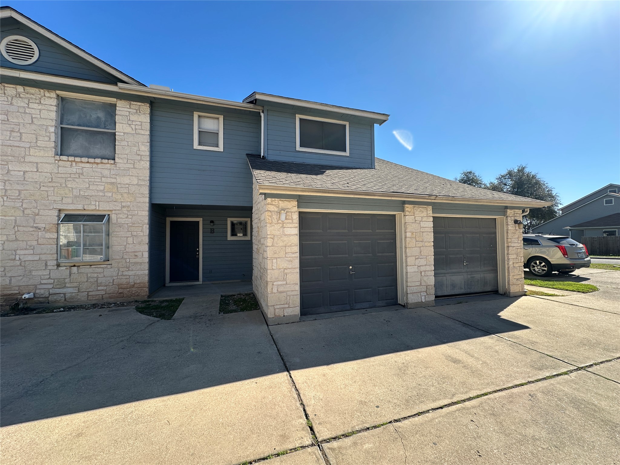 8814 Schick Road, Unit B Austin, TX 78729 - Photo 1 of 36 View of front of home with stone siding, driveway, and a shingled roof