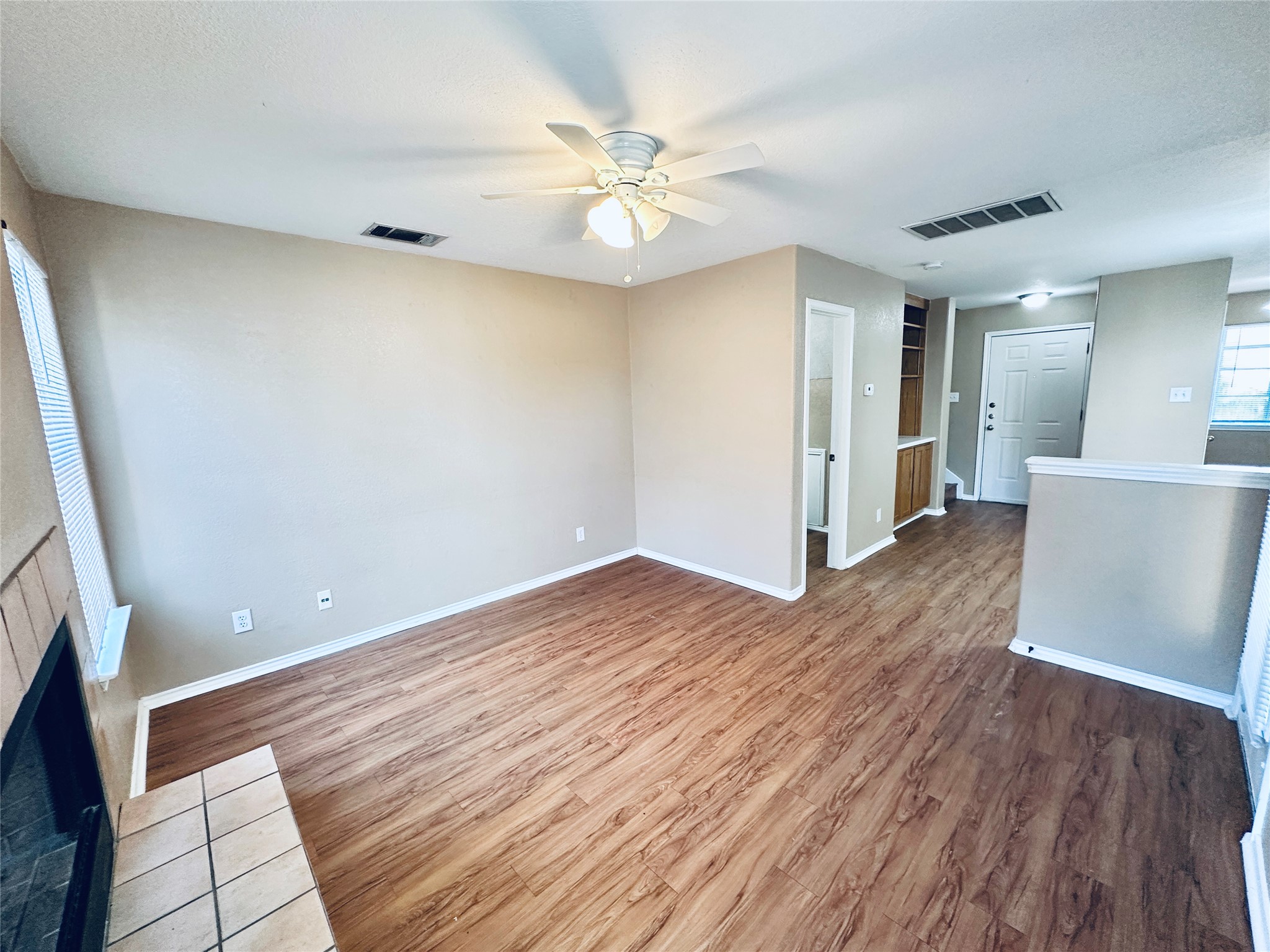 8814 Schick Road, Unit B Austin, TX 78729 - Photo 15 of 36 Unfurnished living room featuring light wood-style floors, a ceiling fan, and a brick fireplace