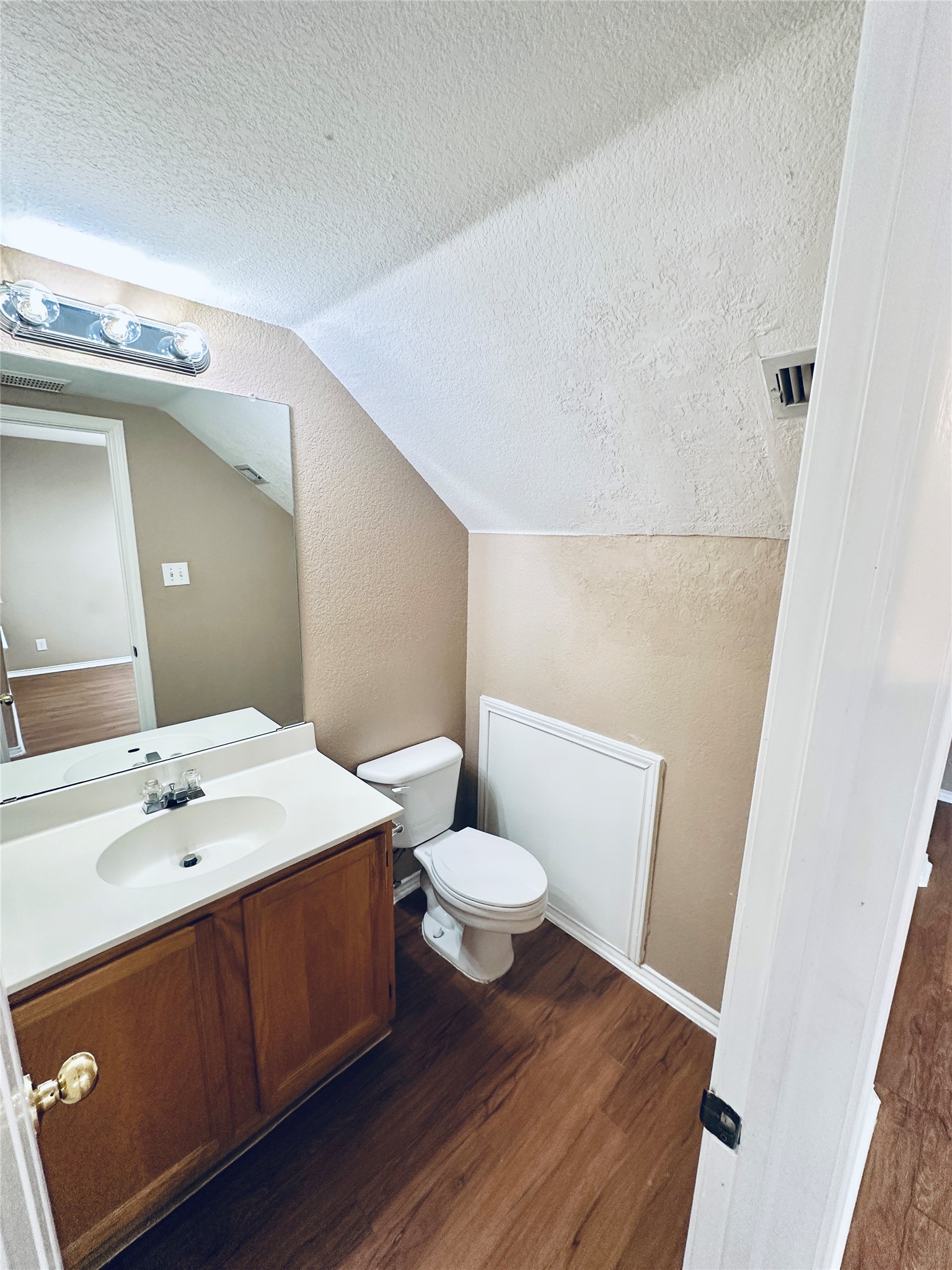 8814 Schick Road, Unit B Austin, TX 78729 - Photo 16 of 36 Bathroom with vanity, dark wood finished floors, and a textured wall