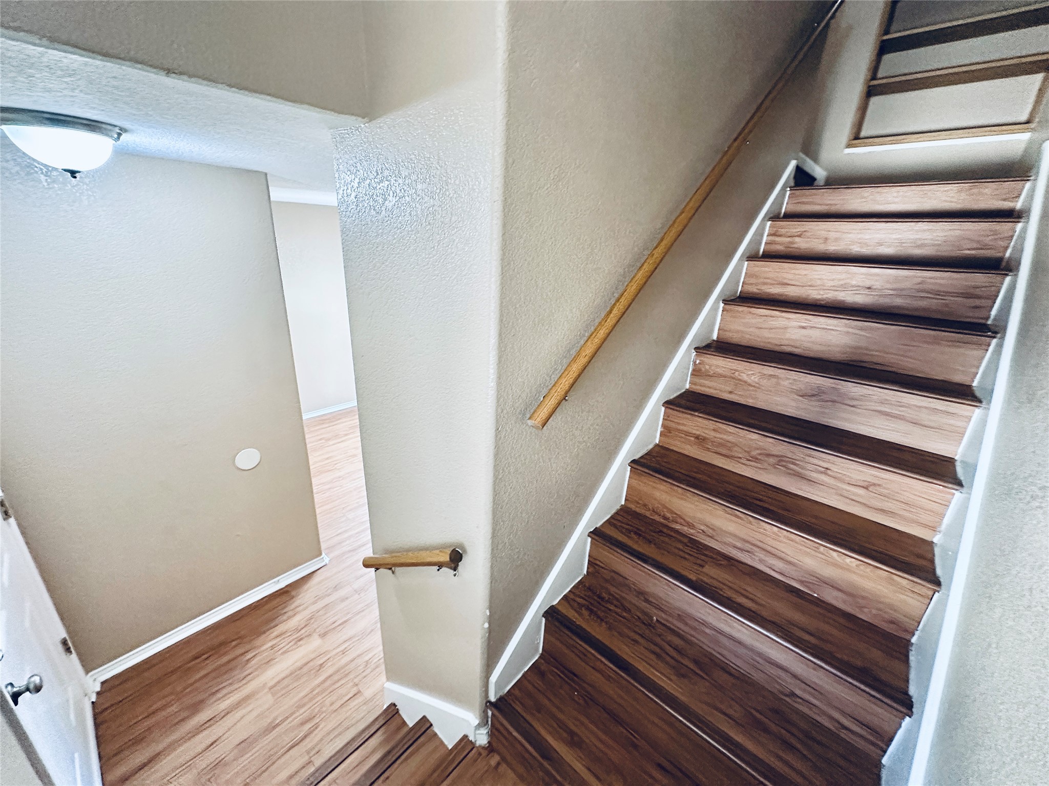 8814 Schick Road, Unit B Austin, TX 78729 - Photo 18 of 36 Stairway with a textured wall and wood finished floors