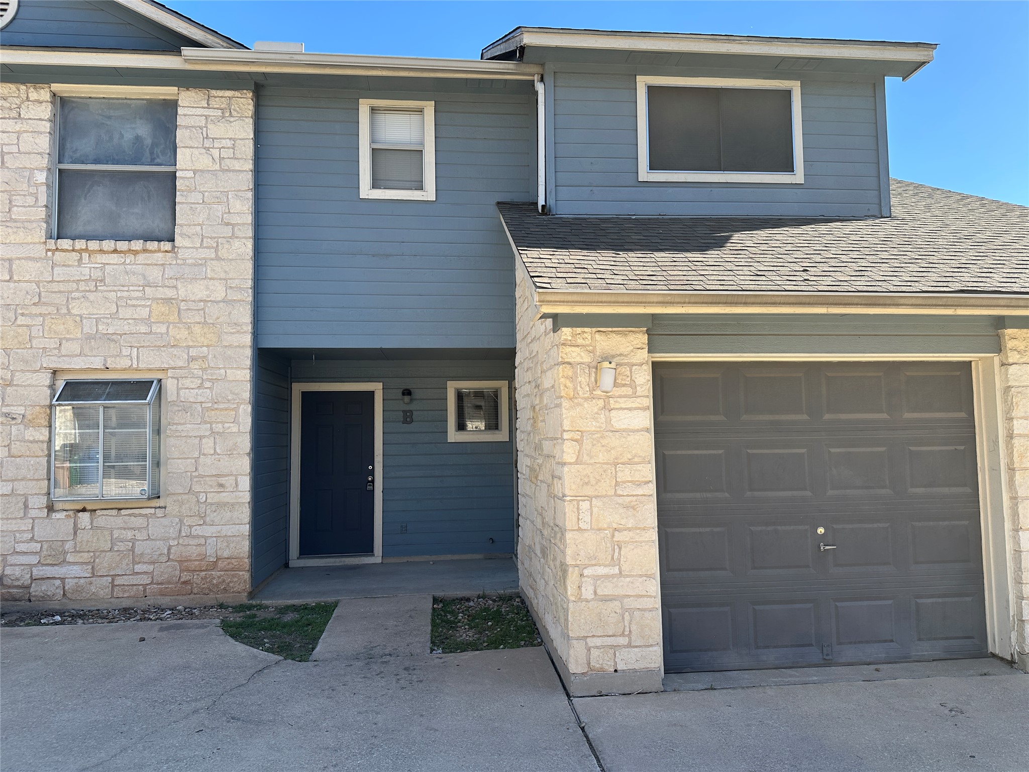 8814 Schick Road, Unit B Austin, TX 78729 - Photo 2 of 36 View of front facade with stone siding and a shingled roof