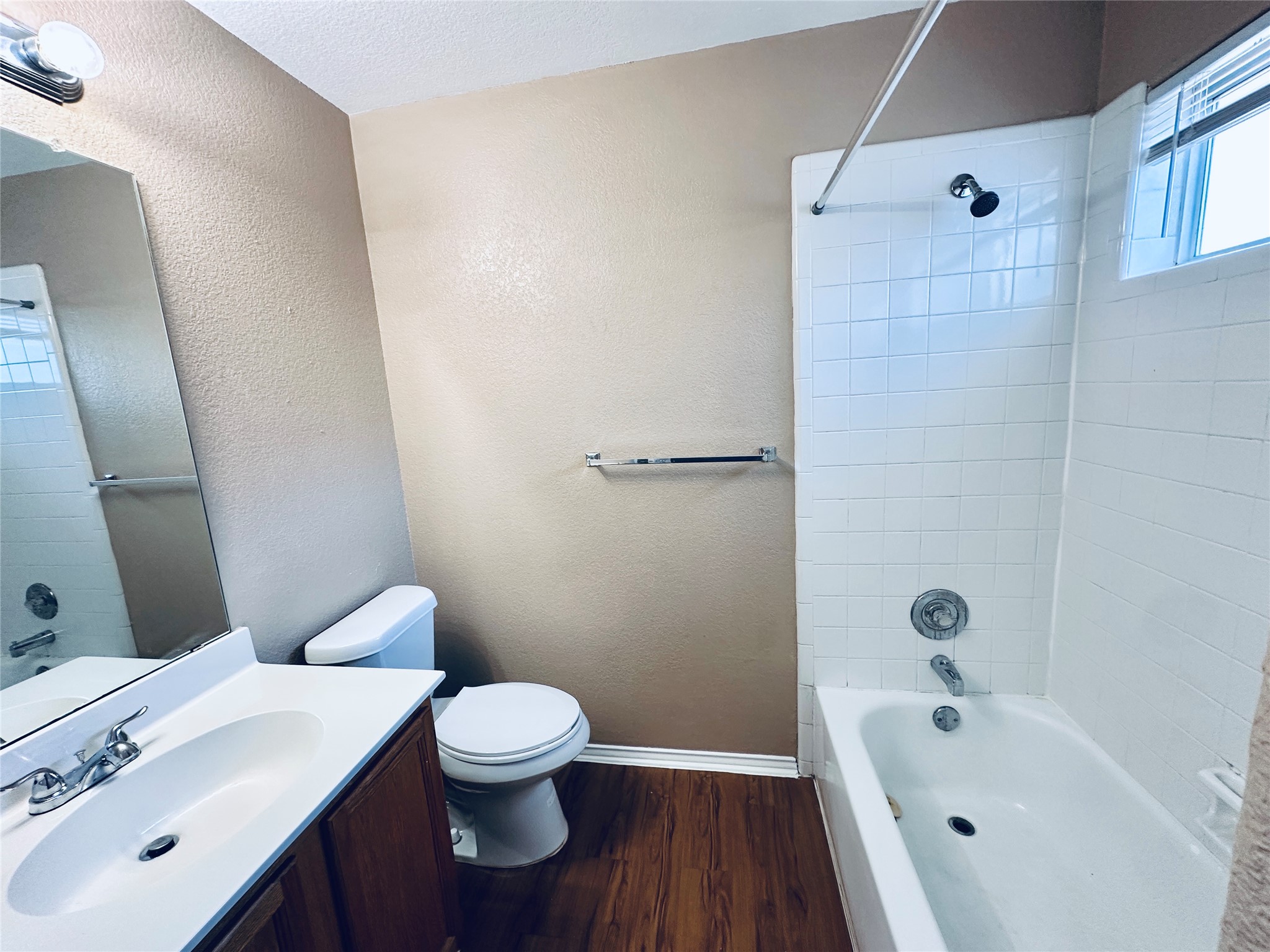 8814 Schick Road, Unit B Austin, TX 78729 - Photo 25 of 36 Full bath featuring vanity, dark wood-style flooring, shower / tub combination, and a textured wall