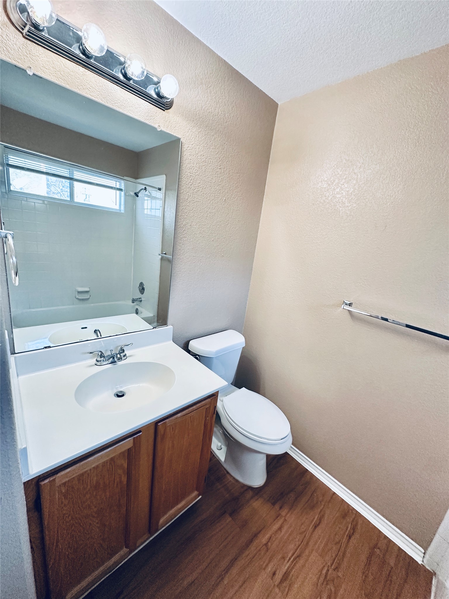 8814 Schick Road, Unit B Austin, TX 78729 - Photo 26 of 36 Bathroom with a textured wall, vanity, dark wood-style flooring, shower / bathtub combination, and a textured ceiling