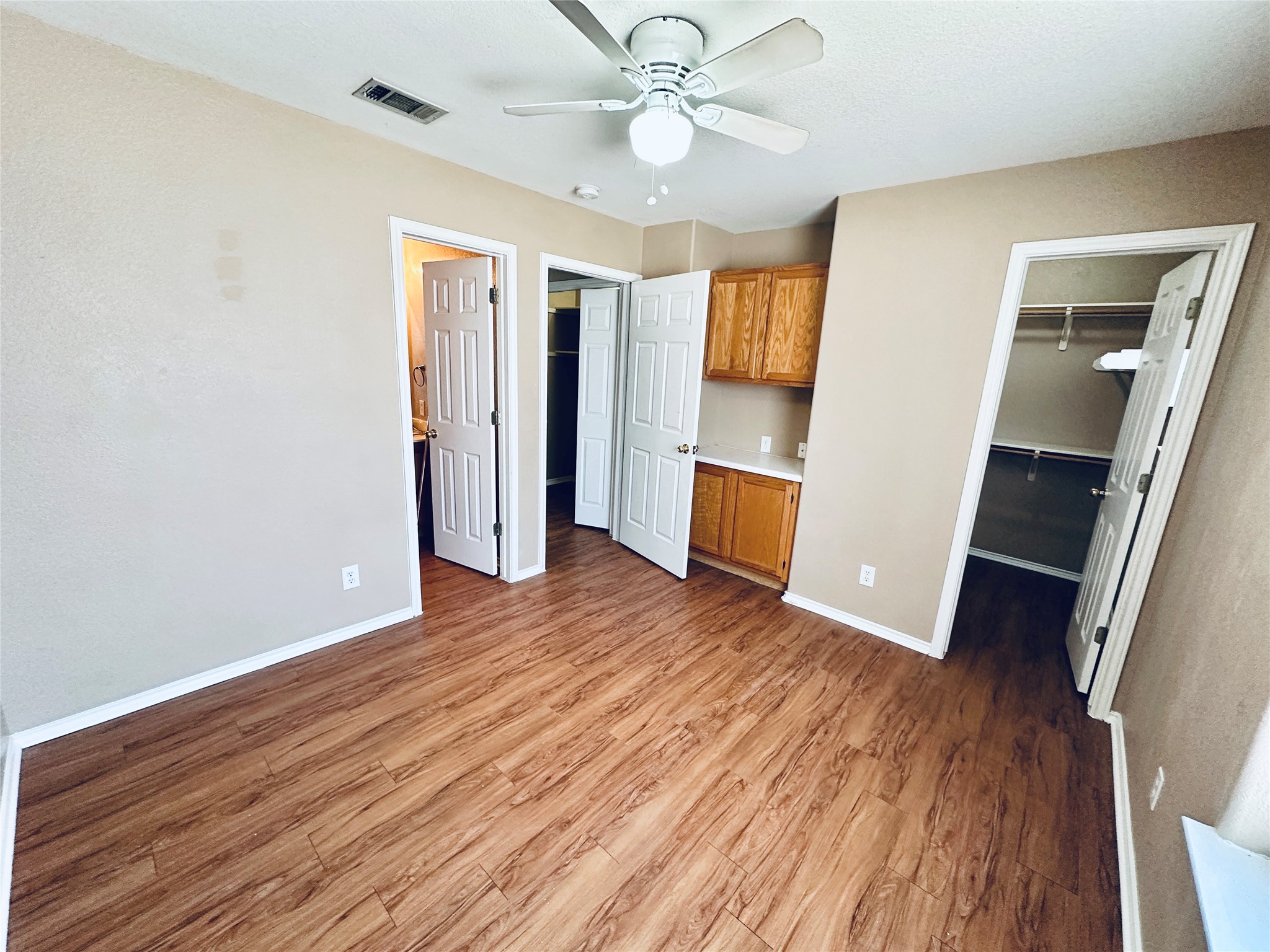 8814 Schick Road, Unit B Austin, TX 78729 - Photo 31 of 36 Unfurnished bedroom with a spacious closet, light wood-style floors, and a ceiling fan