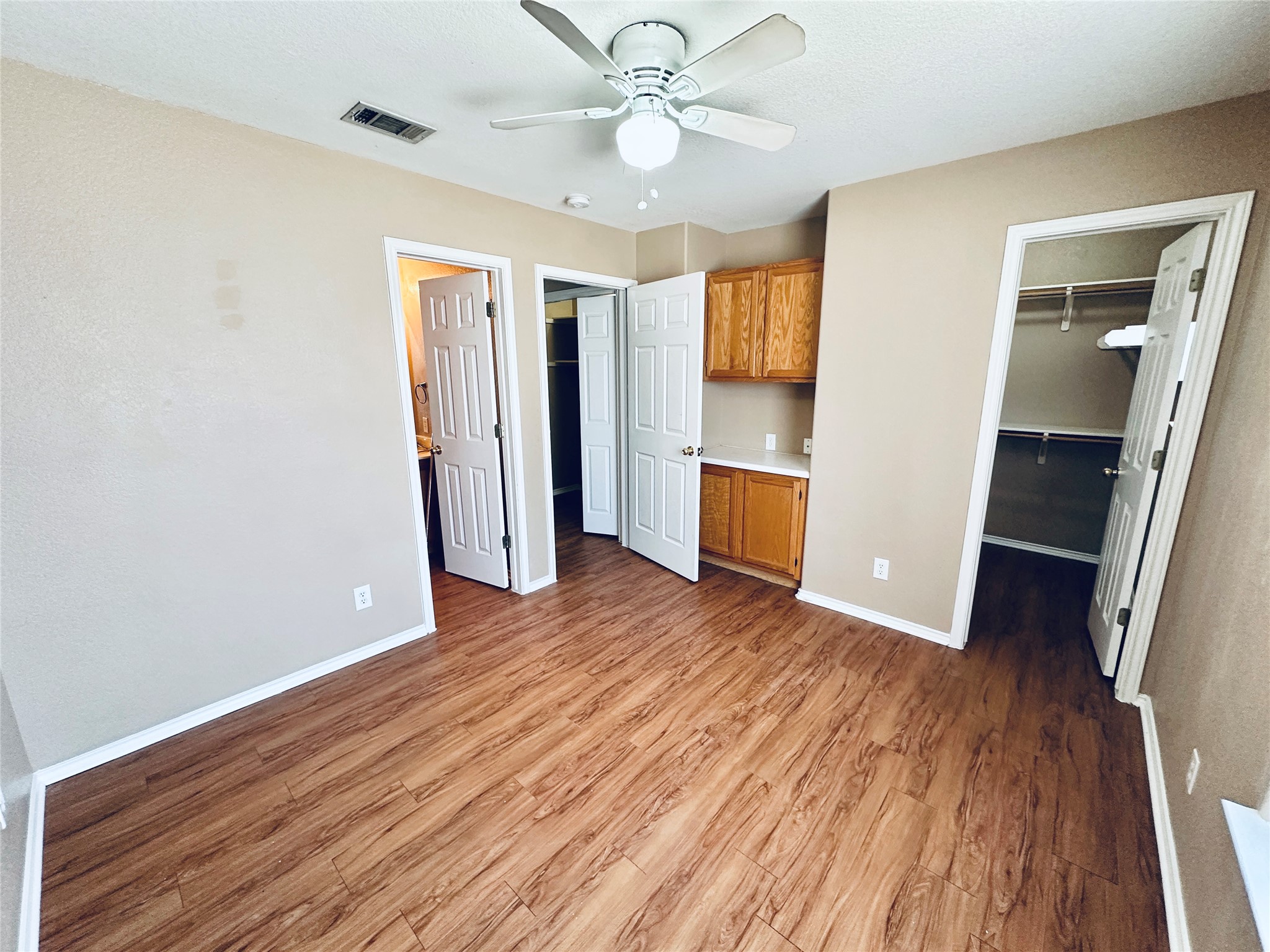 8814 Schick Road, Unit B Austin, TX 78729 - Photo 32 of 36 Unfurnished bedroom featuring a spacious closet, light wood-style flooring, and ceiling fan